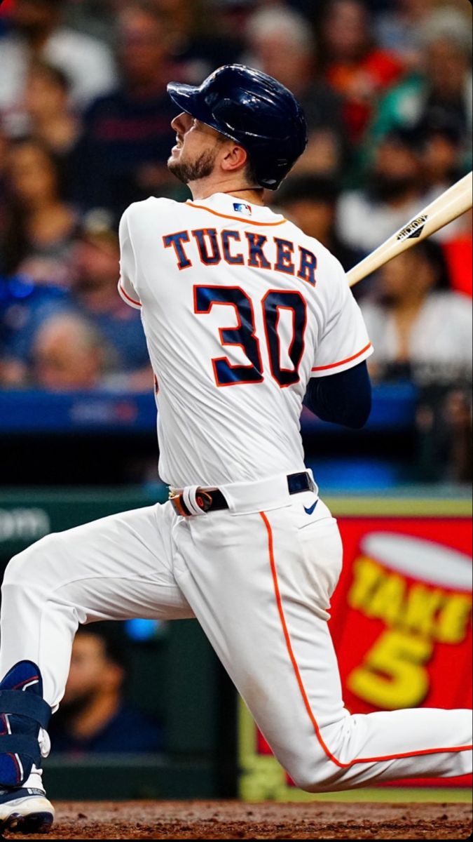 a baseball player swinging a bat on top of a field in front of a crowd