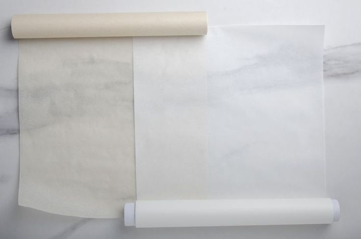 a roll of white paper sitting on top of a table next to a rolled up piece of paper