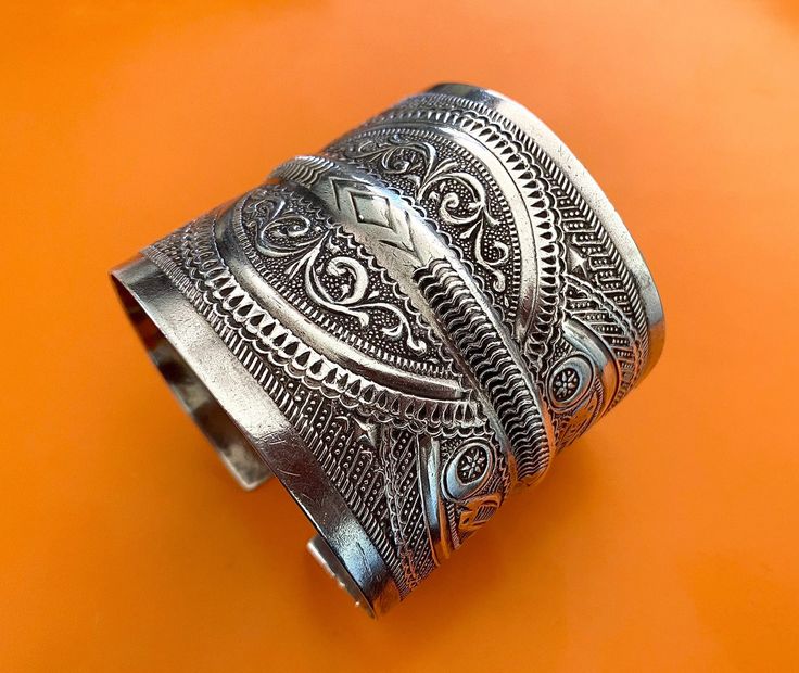 "Presenting a wonderful vintage, solid silver cuff BRACELET from Tunisia. The bracelet measures over 2 1/2\" (6,45 cm) wide and its inner diameter is 2 3/4\" (7,0 cm), though it is FULLY ADJUSTABLE. The bracelet features wonderfully textured floral and geometric designs. It has Tunisian and Libyan hallmarks for 800 silver. This piece is also an excellent size for a man's wrist." Ornate Handmade Bangle In Antique Silver, Ornate Handmade Antique Silver Bangle, Handmade Ornate Antique Silver Bangle, Handmade Antique Silver Cuff Bracelet For Ceremonial, Handmade Antique Silver Cuff Bracelet For Ceremonial Occasions, Antique Handmade Cuff Bracelet, Unique Handmade Cuff Bracelet For Ceremonial Use, Traditional Engraved Cuff Bracelet, Bohemian Silver Cuff Bracelet With Intricate Design