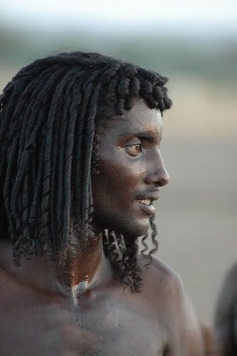 a man with dreadlocks on his head and no shirt