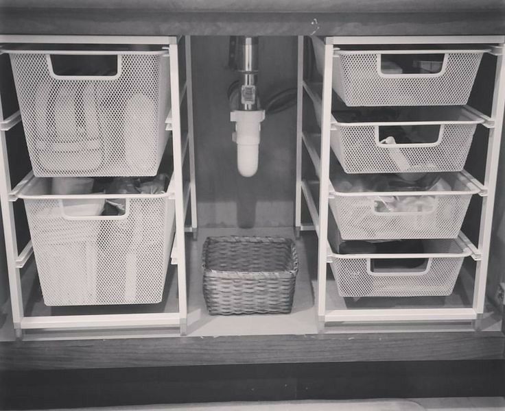 an organized closet with baskets and toiletries in black and white photo by john koster