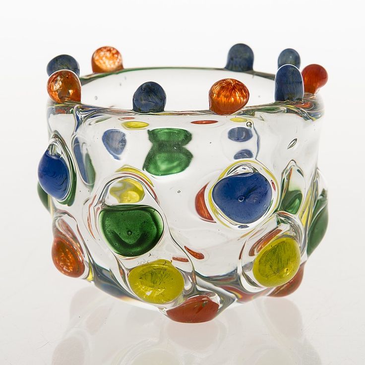 a colorful glass vase sitting on top of a white table