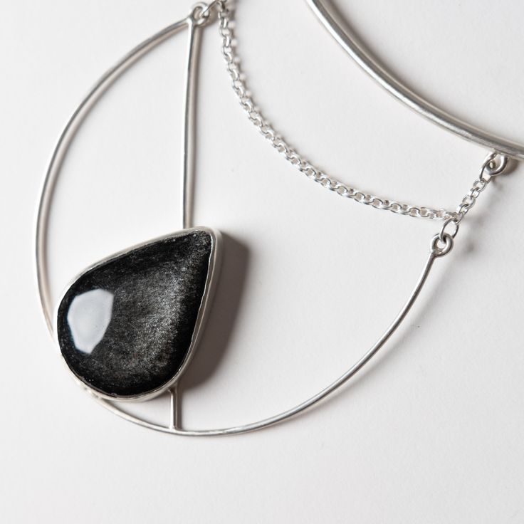 This one of a kind statement piece is hand fabricated in sterling silver, with a beautiful silver sheen obsidian. Collar size is slightly adjustable. Handcrafted in San Francisco. In stock and ready to ship. Black Sterling Silver Jewelry, Modern Adjustable Jewelry With Large Stone, Modern Sterling Silver Jewelry With Large Stone, Silver Obsidian Pendant Necklace, Silver Minimalist Jewelry With Large Stone, Modern Silver Jewelry With Large Stone, Minimalist Silver Jewelry With Large Stone, Silver Obsidian Gemstone Necklace, Silver Onyx Gemstone Jewelry