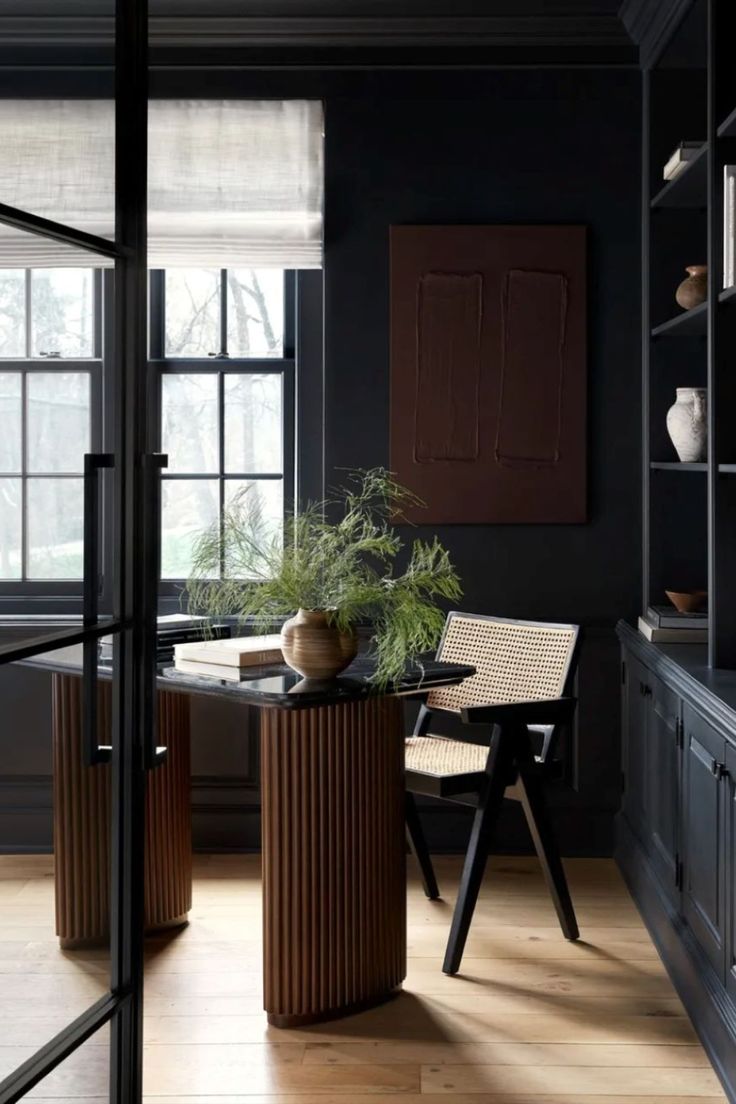 a dining room with black walls and wooden floors