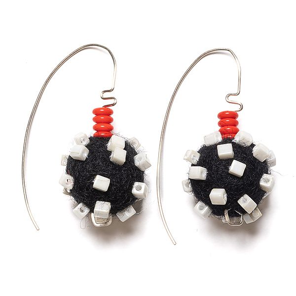 the earrings are made with black and white beads, red thread, and silver earwires