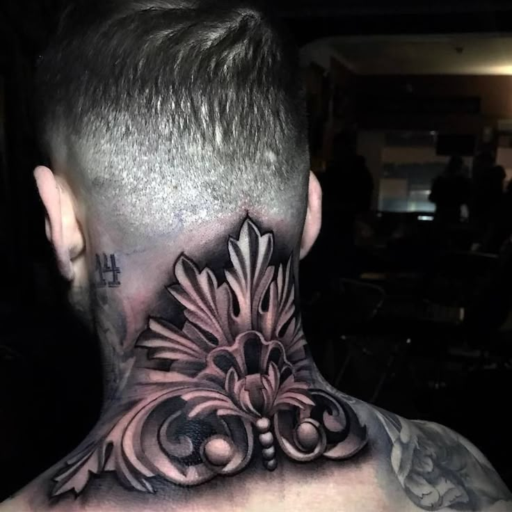 a man with tattoos on his neck and back