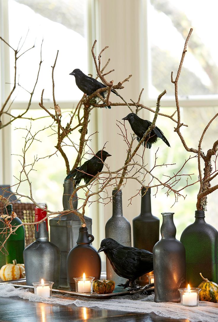 there are many vases with birds on them and candles in front of the window