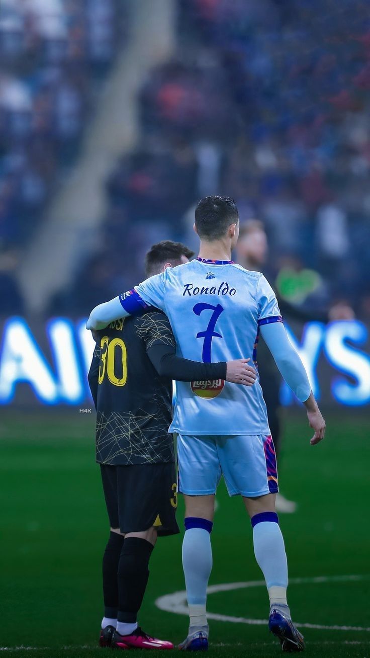 two soccer players embracing each other on the field