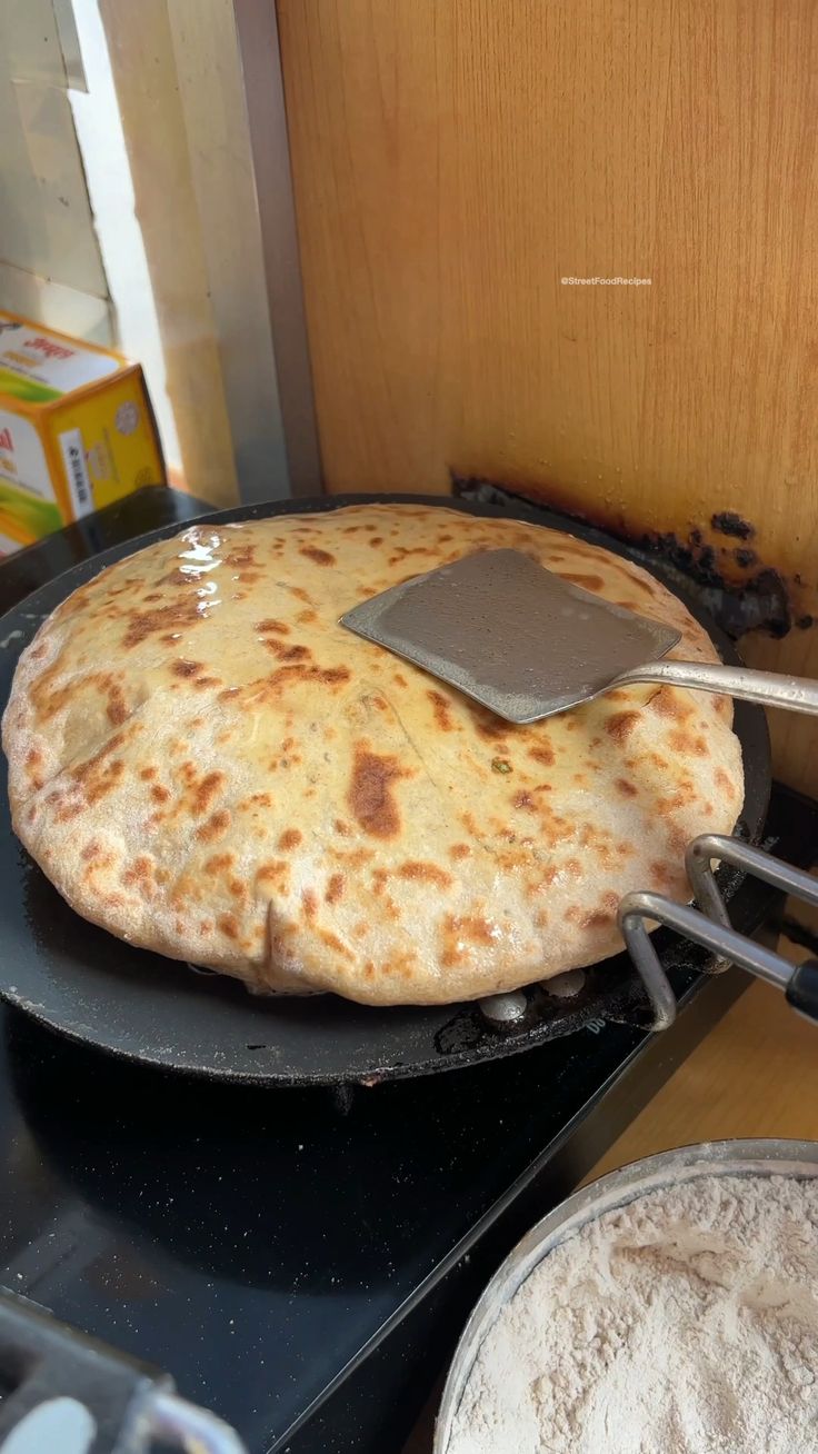 a pizza being cooked on top of a stove