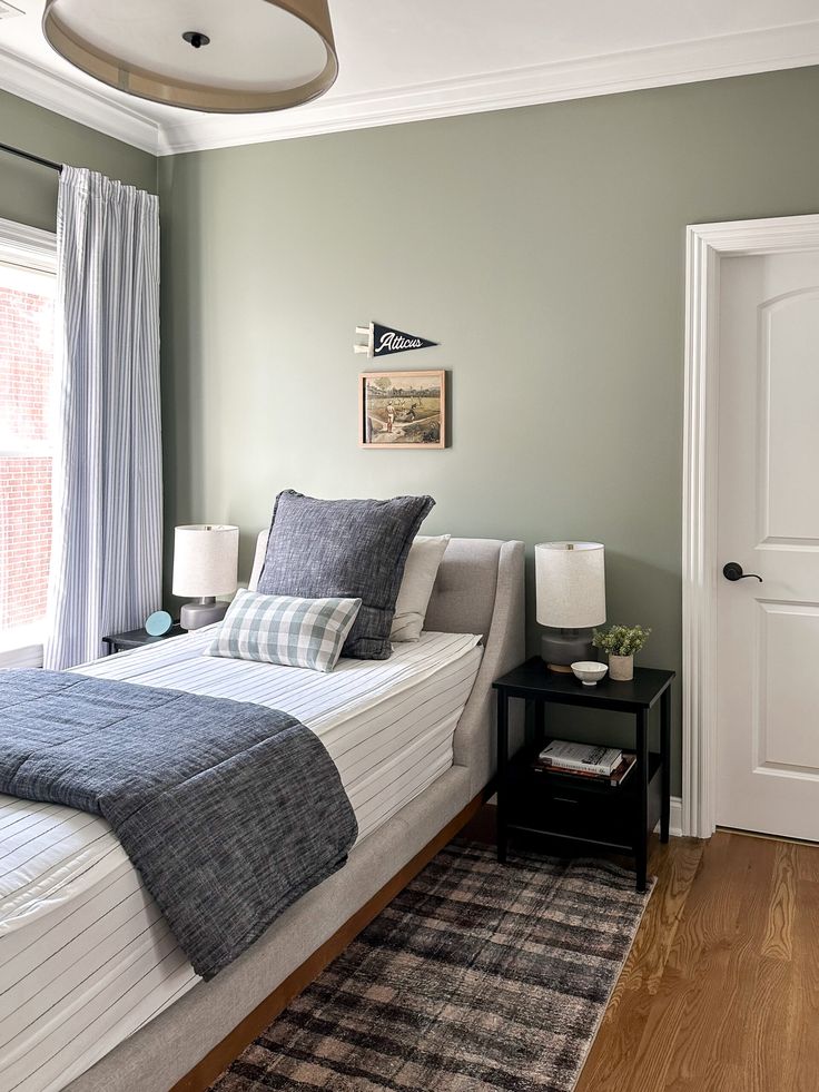 a bedroom with green walls and white bedding