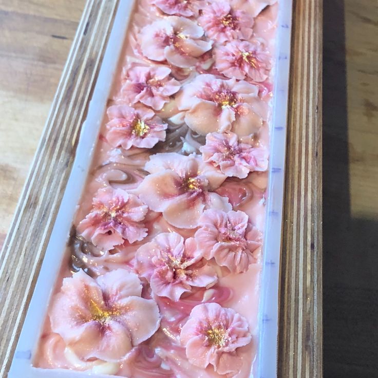 an empty box filled with pink flowers on top of a wooden table