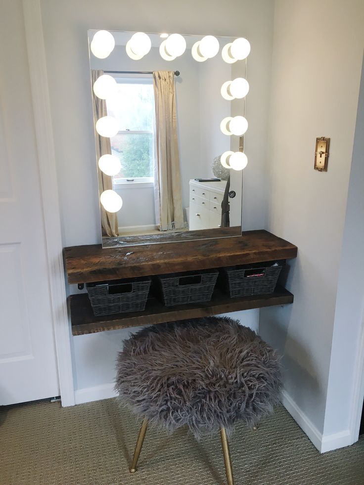 a vanity with lights and stool in front of it