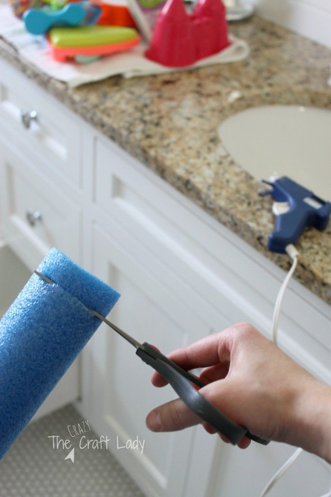 a person is holding a pair of scissors in front of a blue roll of toilet paper