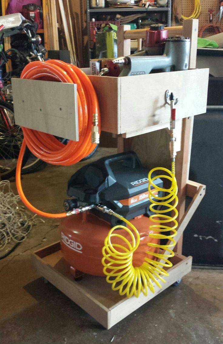 an orange hose is hooked up to the back of a machine in a garage with other tools