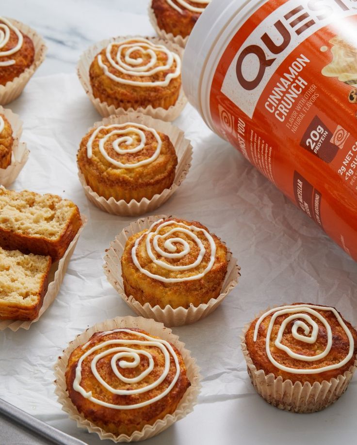 cupcakes with cinnamon swirl frosting next to a bottle of orange juice