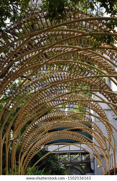 an arch made out of wicker with trees in the background