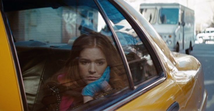 a woman sitting in the passenger seat of a taxi talking on her cell phone