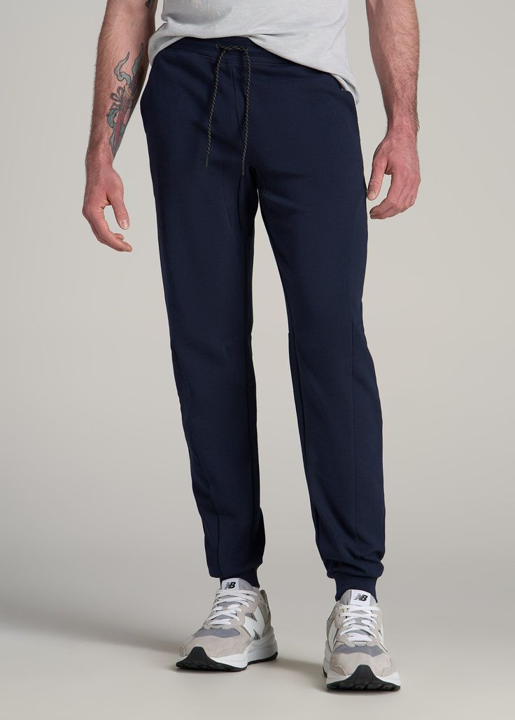 Discover the Ultimate Joggers for Tall Men Comfort Meets Utility in These Tall Men's Jogger Pants Our Utility Joggers redefine the standard for athletic pants. Designed for tall men, these extra-long men's joggers blend a modern fit with practical functionality, perfect for an active lifestyle or a relaxed day. They are the epitome of comfort and utility, tailored for those who are tall and seek style without compromise. Athletic jogger style with a modern fit Stretch fabric and waistband for ma Functional Blue Bottoms With Elastic Waistband, Functional Blue Jogging Bottoms, Functional Blue Pants With Elastic Waistband, Training Pants With Pockets And 4-way Stretch, Training Pants With 4-way Stretch And Pockets, Blue Workout Bottoms With Elastic Side Panels, 4-way Stretch Bottoms With Pockets For Jogging, 4-way Stretch Bottoms With Elastic Side Panels For Jogging, Casual Training Pants With Pockets