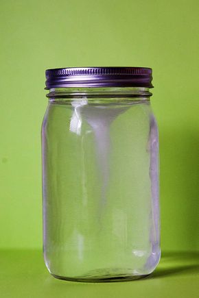 a glass jar sitting on top of a green table