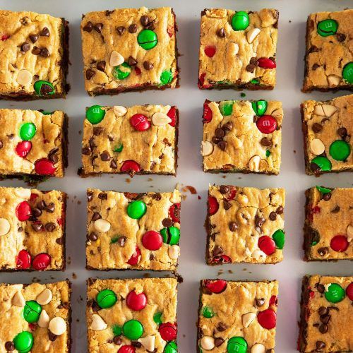 christmas cookie bars with candy and m & m's on top are arranged in rows