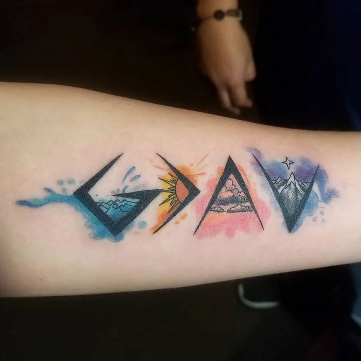 a person with a tattoo on their arm that has three different colored triangles in it