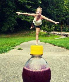 a woman balancing on top of a soda bottle