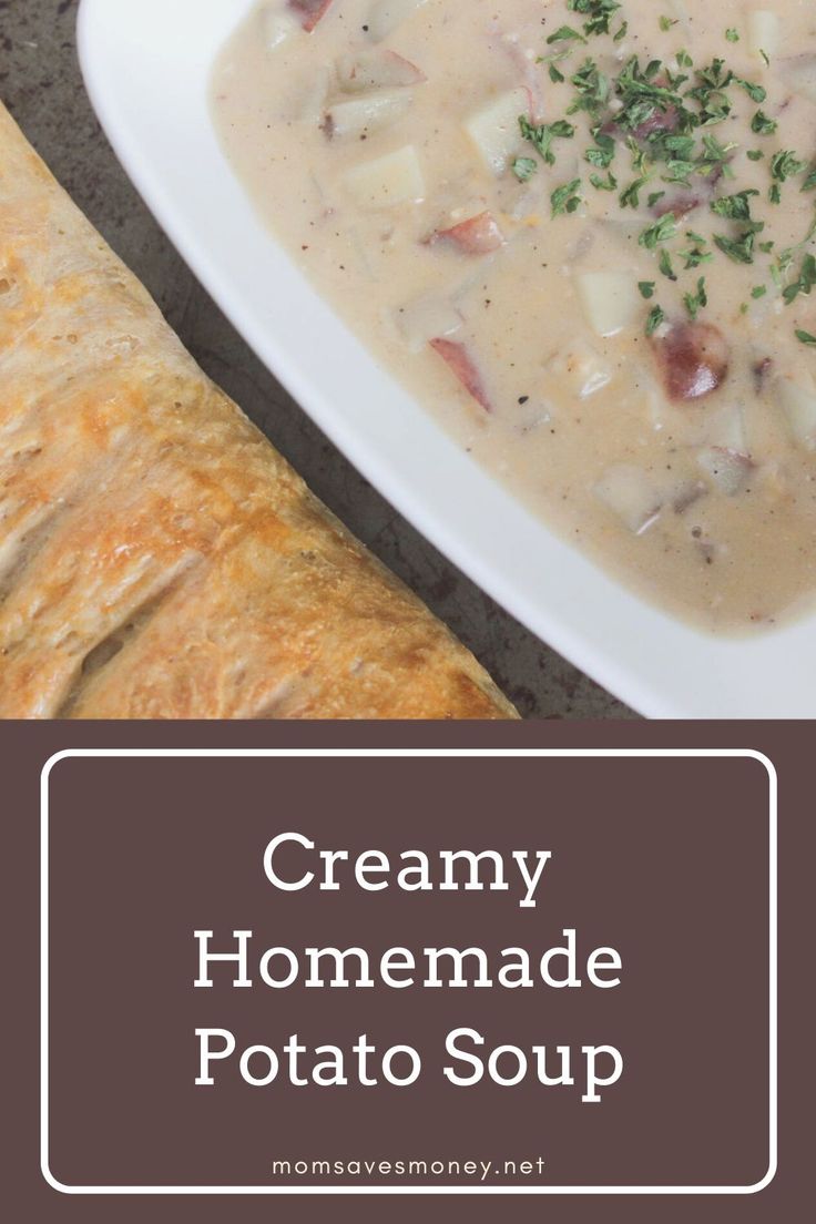 creamy homemade potato soup in a white bowl next to a piece of bread on a plate