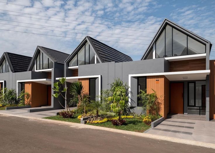 two story houses with brown doors and windows on the side of the street in front of palm trees