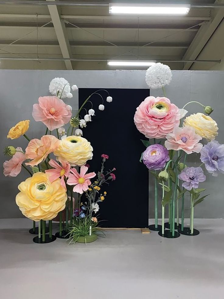 three tall vases with flowers in them