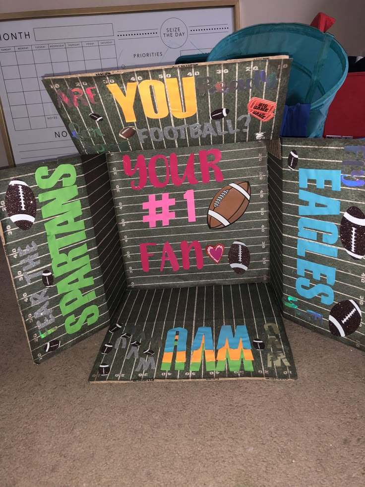 three cardboard boxes with different designs and words on them, all stacked up in the shape of footballs