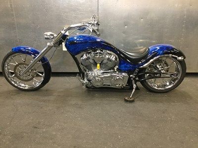 a blue motorcycle parked in front of a metal wall