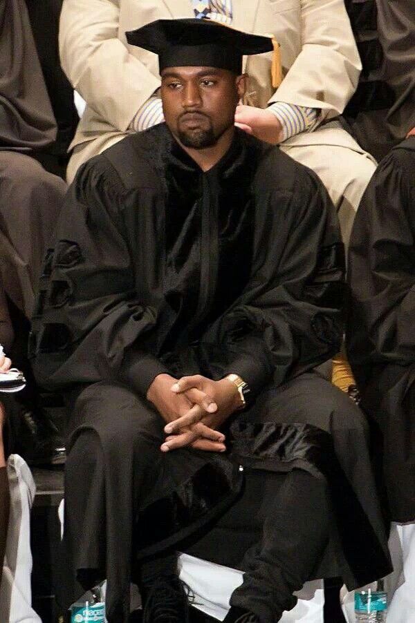 a man in a black outfit and hat sitting down