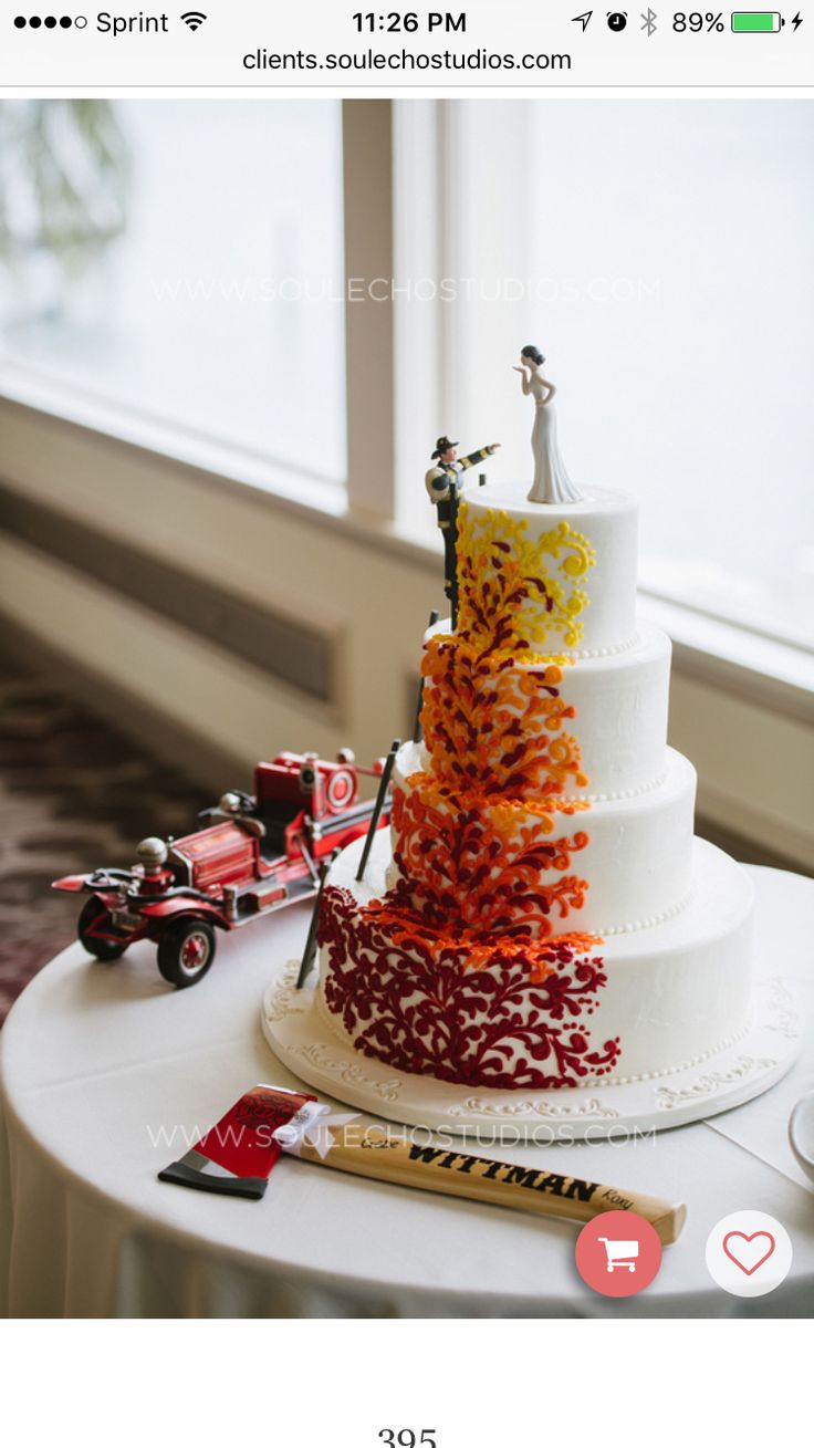 the wedding cake is decorated with red, yellow and orange flowers on it's tiers