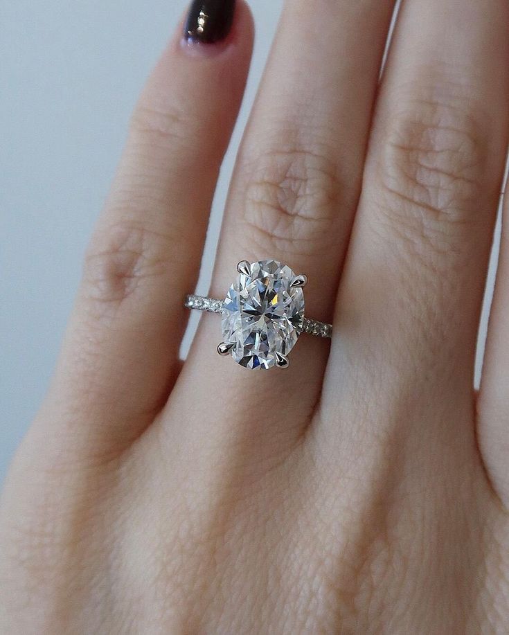 a woman's hand with a ring on it and a diamond in the middle