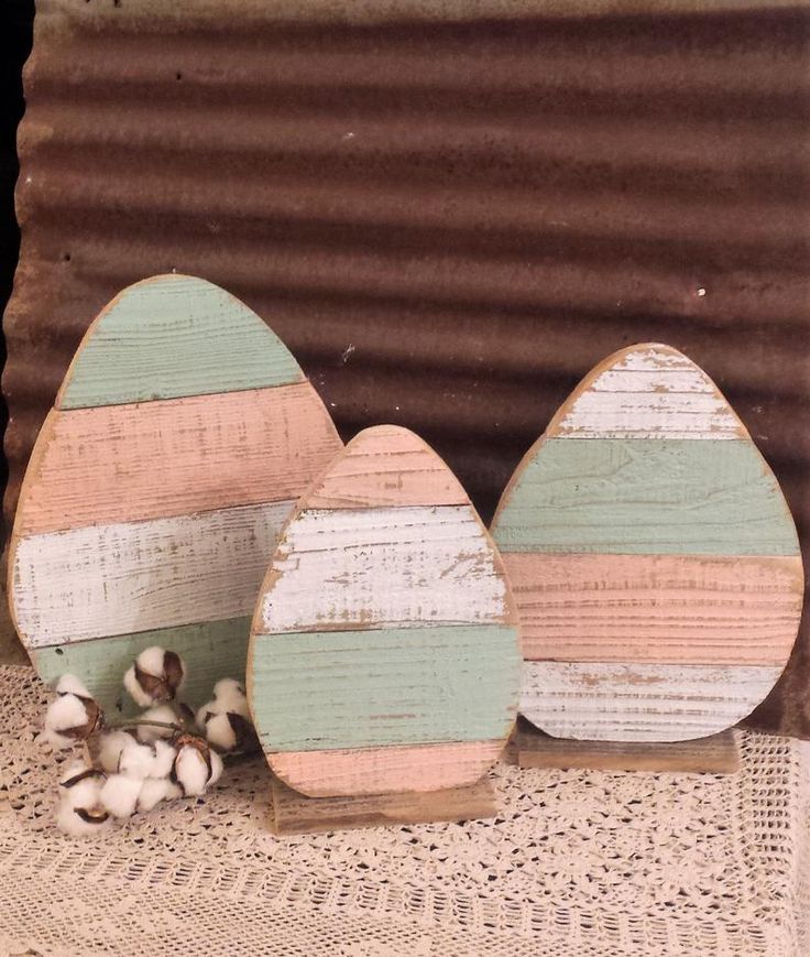 three wooden eggs sitting on top of a table