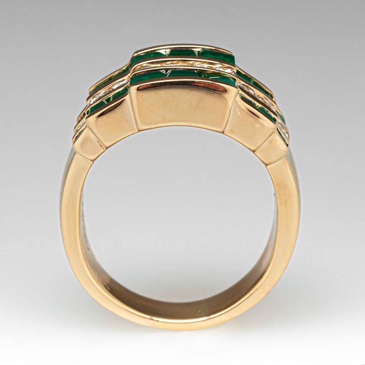 This colorful alternating wide band ring is accented with ten (10) round brilliant cut diamonds, and eighteen (18) square step cut natural emeralds set into channels. The ring measures 11.5mm at the top, rises 4.4mm above the finger, tapering to 4.7mm wide and 1.4mm thick at the base of the shank. The ring crrently fits a 5.5. Luxury Rectangular Channel Set Ring, Formal Emerald Channel Set Jewelry, Luxury Channel Set Rectangular Ring, Gold Emerald Ring With Channel Set Emerald Cut, Luxury Channel Set Emerald Ring For Anniversary, Green Emerald-cut Channel Set Jewelry, Luxury Emerald Ring With Diamond Channel Set, Formal Fine Jewelry Emerald Ring Channel Set, Luxury Emerald Diamond Ring With Channel Set