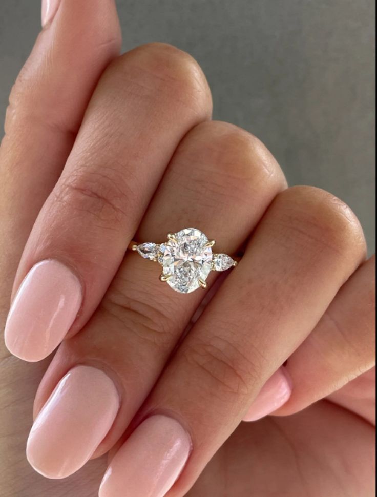 a woman's hand holding a diamond ring