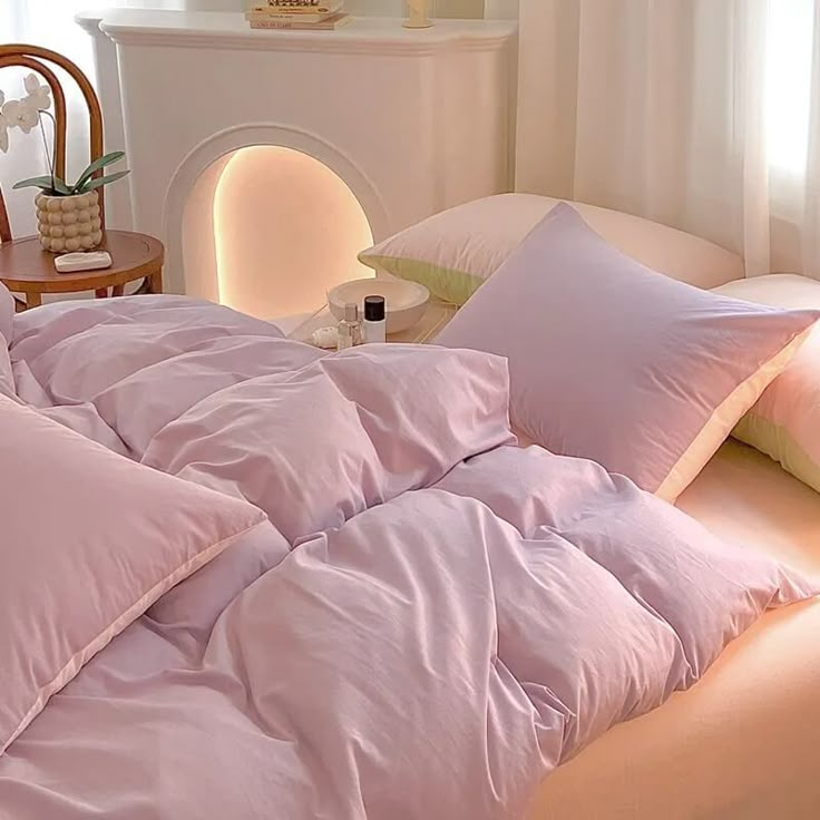 an unmade bed with pink sheets and pillows