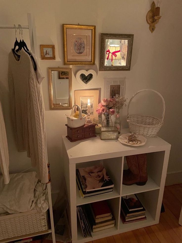 a white shelf with books and pictures on it