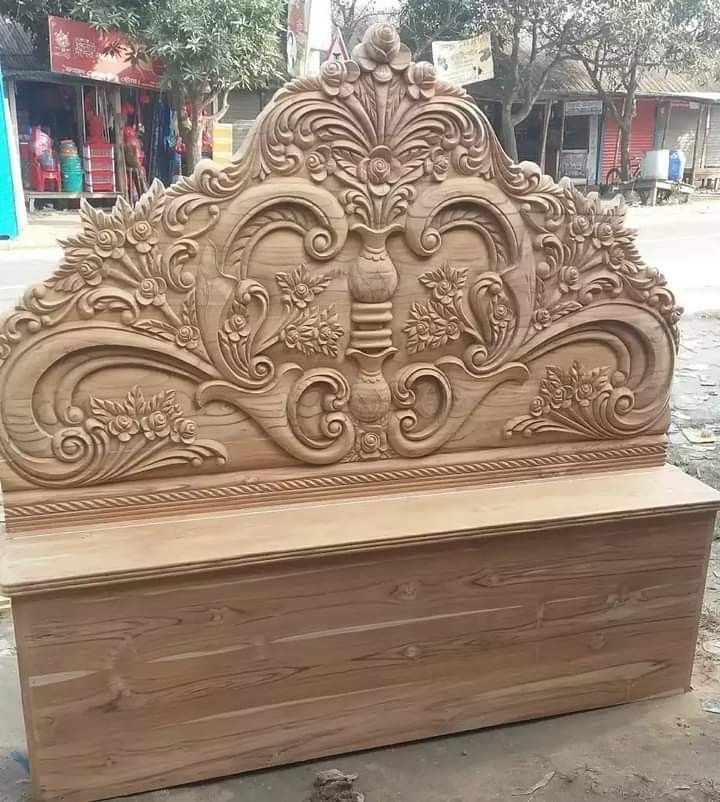 a carved wooden bench sitting on top of a sidewalk