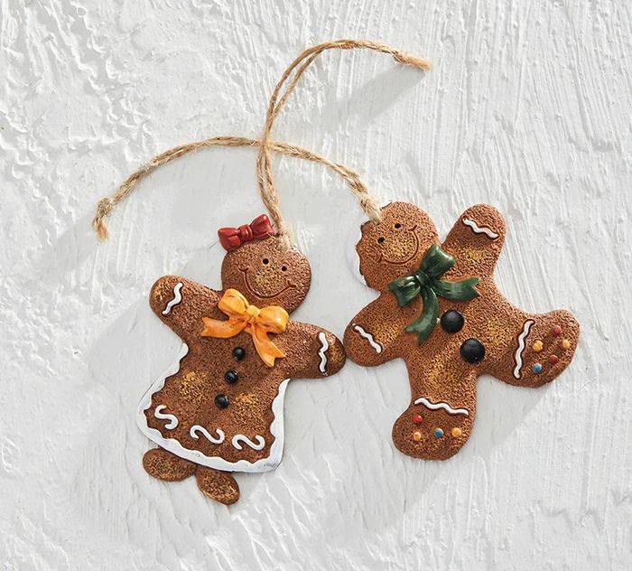 two gingerbread christmas ornaments hanging from twine