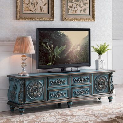 an ornately decorated entertainment center with a flat screen tv on it's stand