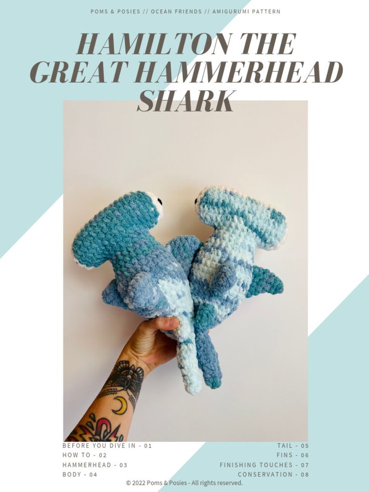 two small stuffed animals in the shape of sharks are being held by someone's hand