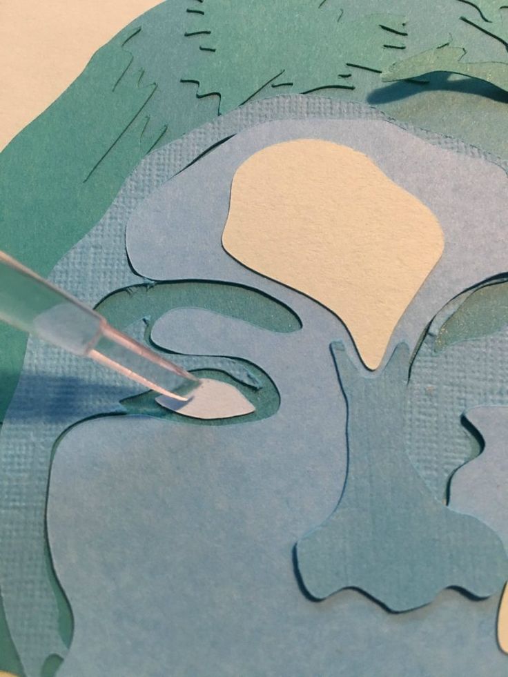 a person cutting out paper with scissors on top of the cutout shapes for a woman's face