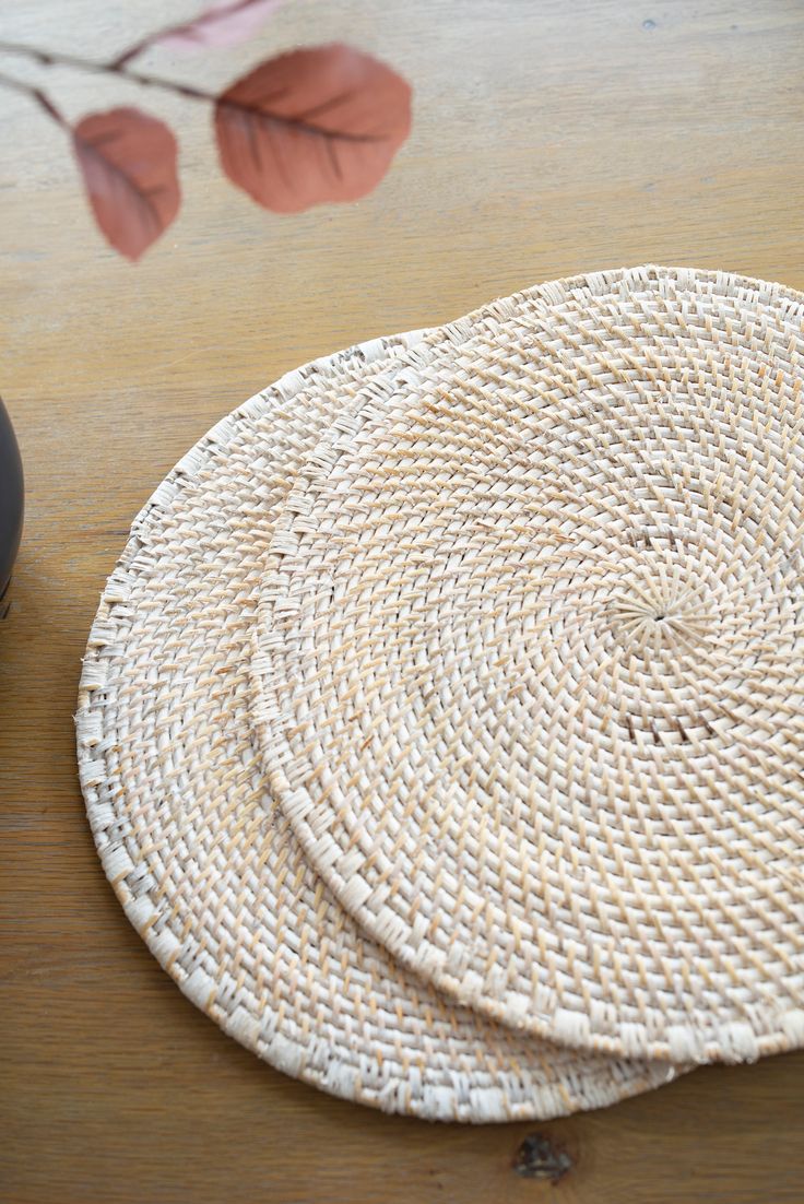 two woven coasters sitting on top of a wooden table