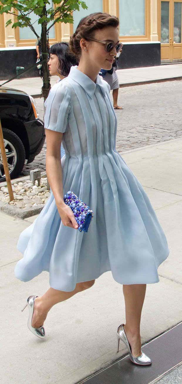 a woman in a blue dress is walking down the street