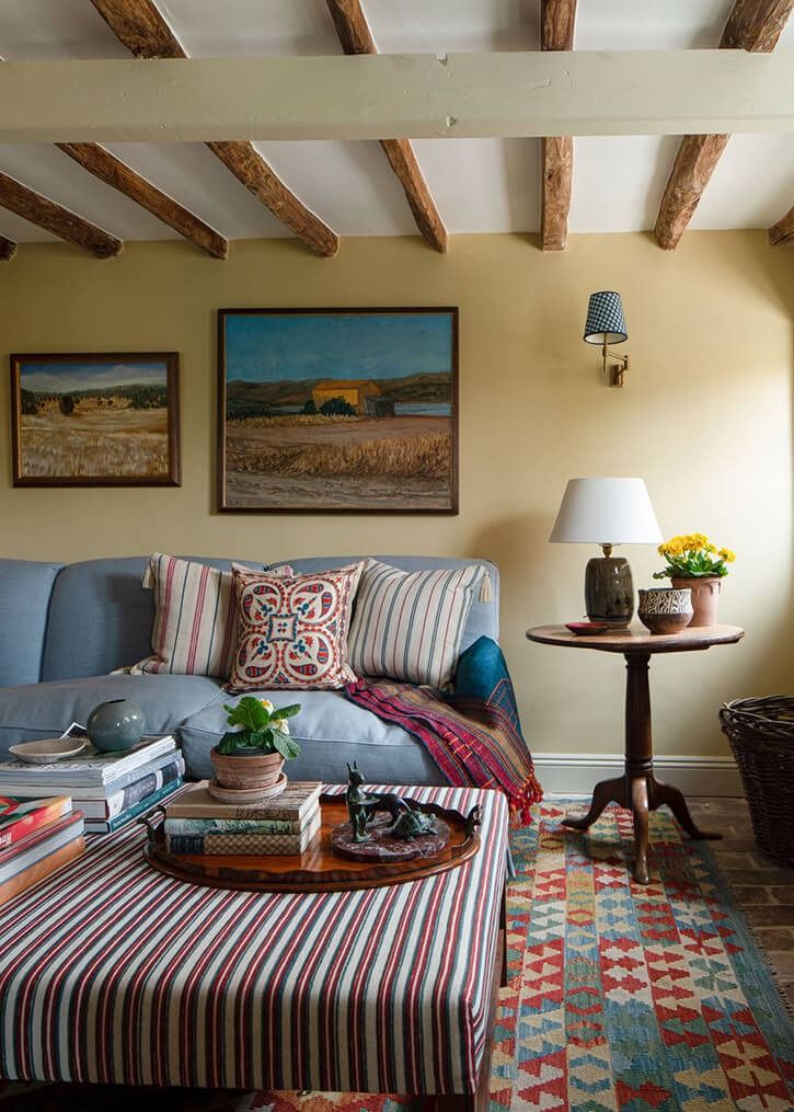 a living room filled with furniture and paintings on the wall above it's coffee table