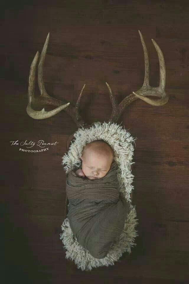 a baby is wrapped in a blanket with antlers on it's head and sleeping