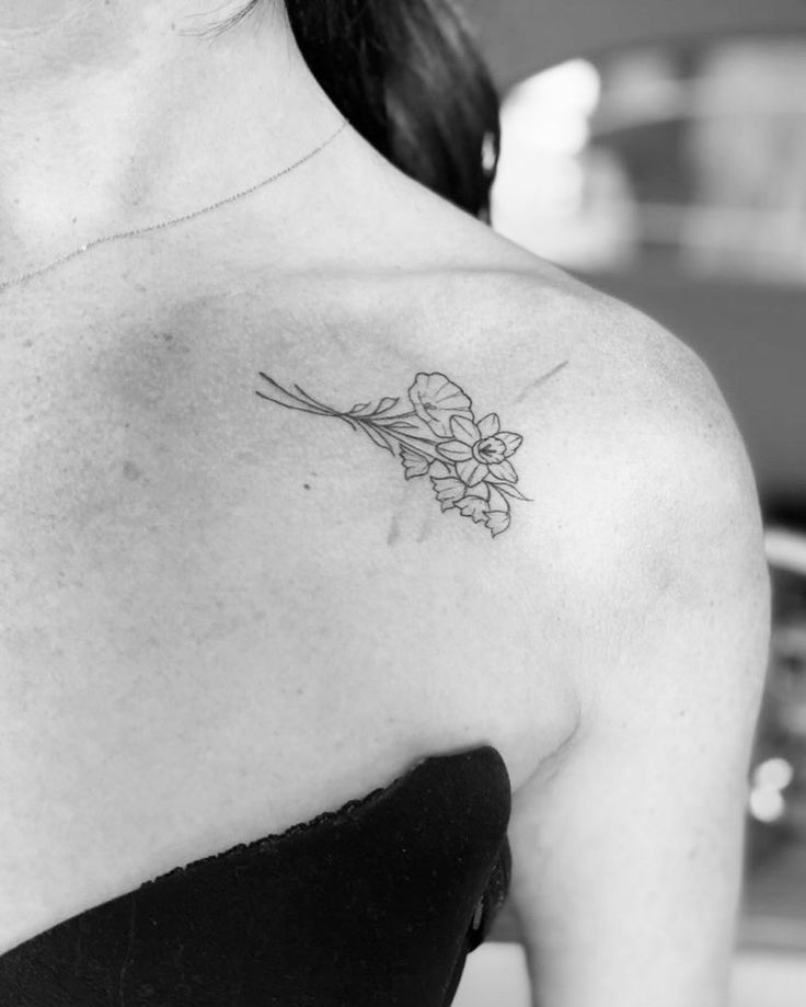 a woman with a flower tattoo on her shoulder