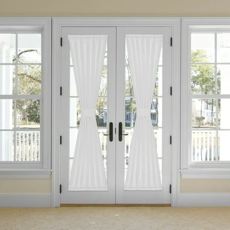 two white french doors with sheer curtains on them